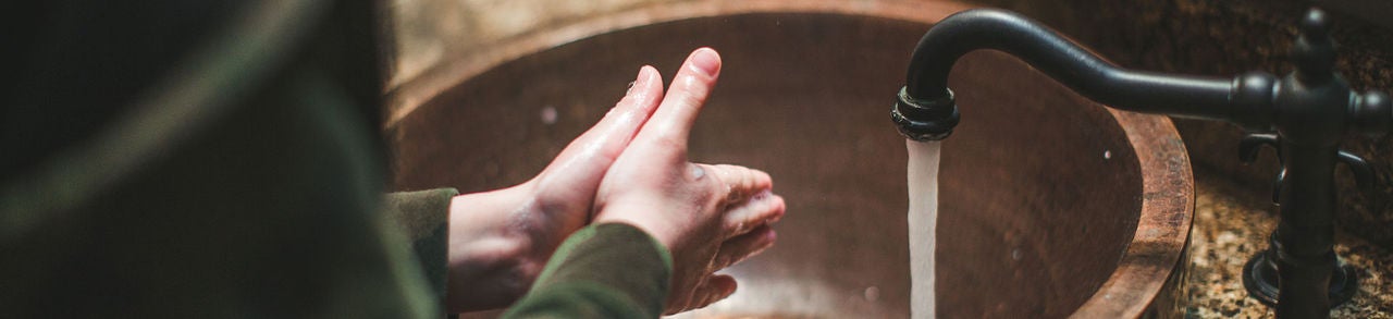 Lavarse las manos en el lavabo del baño